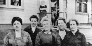 Photograph of 5 women in front of a building.