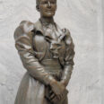 Statue of Martha Hughes Cannon with hands clasped over a book, standing in the Utah State Capitol, closeup