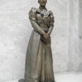 Statue of Martha Hughes Cannon with hands clasped over a book, standing in the Utah State Capitol